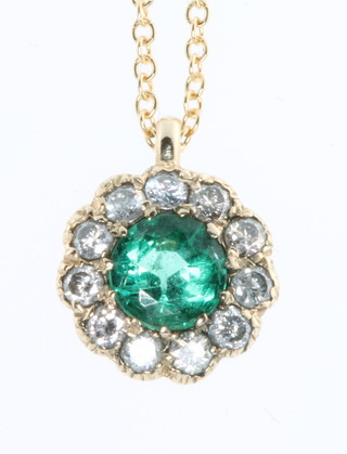 A yellow gold emerald and diamond cluster pendant, the centre stone approx. 0.5ct surrounded by brilliant cut diamonds on an 18ct yellow gold chain 