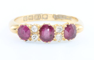 An 18ct yellow gold ruby 3 and diamond 4 stone ring, size N 1/2