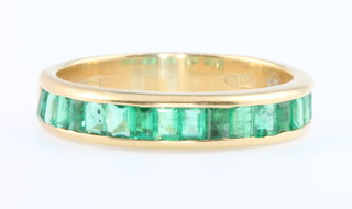 An 18ct yellow gold 16 stone emerald half eternity ring, size N 1/2 