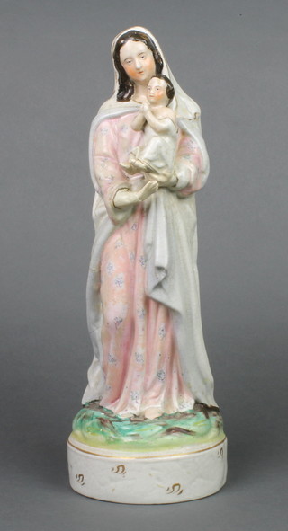 A Victorian Staffordshire figure of The Virgin Mary and child on a raised base 14" 