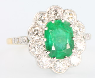 An 18ct yellow gold emerald and diamond oval cluster ring, the centre stone approx. 2.0ct surrounded by 10 brilliant cut diamonds approx 1.25ct 