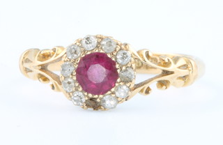 An 18ct yellow gold ruby and diamond cluster ring with open shoulders size N (1 diamond missing) 
