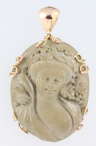 A yellow gold lava cameo pendant in the form of a semi-clad lady 