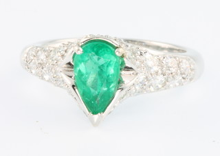 An 18ct white gold pear shaped emerald and diamond ring, the mount stamped Bulgari, the emerald approx. 1.5ct and surrounded by brilliant cut diamonds, size M, in a Bulgari box 