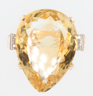 A 14ct yellow gold pear shaped citrine and diamond ring, the pear shaped stone flanked by 4 diamond chips, size O 