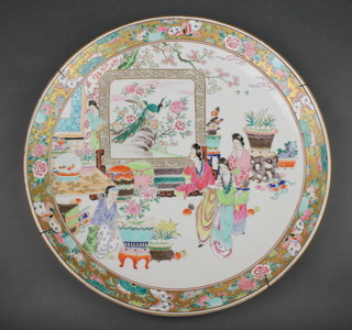 A 19th Century famille rose charger decorated with figures at pursuits before a giant screen depicting an exotic bird within a floral and insect border with 2 character mark to the reverse 18" 