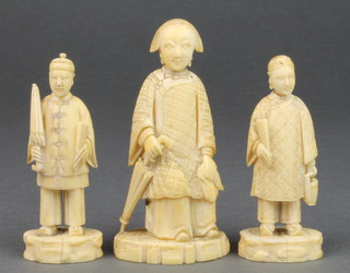 A 19th Century ivory carved figure of a seated Chinese lady holding an umbrella 3 1/2", 2 smaller figures of standing gentleman 1 holding a scroll the other an umbrella 3" 