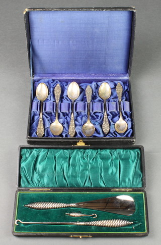 A cased set of 3 toilet accessories with spiral silver handles in a fitted case and 6 cased 800 teaspoons 