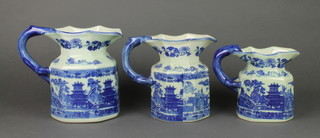 A set of 3 19th Century style graduated blue and white pottery jugs 
