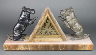 A French Art Deco 8 day striking mantel clock contained in a 2 colour marble pyramid shaped case, the gilt diamond shaped dial with Arabic numerals and flanked by a pair of spelter West Highland Terriers 