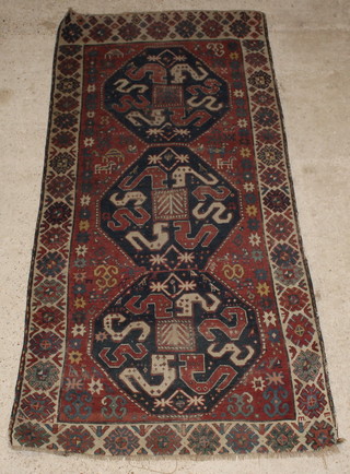 A Kilim rug with 2 octagons to the centre in-wear and holed 105" x 49" 