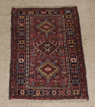 A Persian Karageh blue and red rug with stylised diamonds to the centre 51" x 35"  