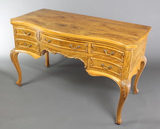 A Maples figured walnut dressing table/writing desk of serpentine outline with quarter veneered top, fitted 1 long drawer flanked by 4 short drawers with brass swan neck drop handles, raised on carved cabriole supports, label to drawer,  29"h x 48"w x 22 1/2"  