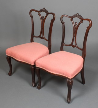 A pair of Victorian mahogany nursing chairs, the over stuffed seats of serpentine outline, raised on cabriole supports