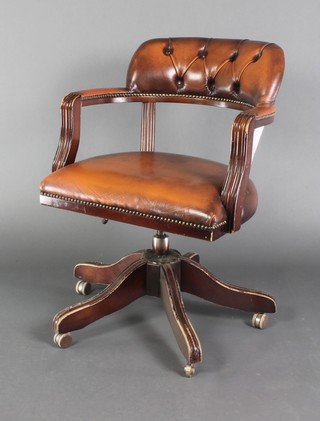 A mahogany framed revolving office chair upholstered in brown "leather" material 