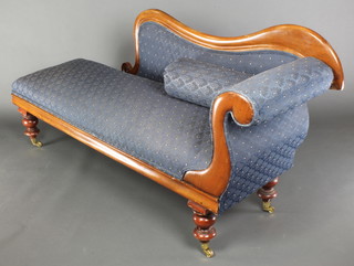 A 19th Century mahogany show frame chaise longue upholstered in blue material, raised on turned supports ending in brass caps and casters 33"h x 69"l x 21"d 