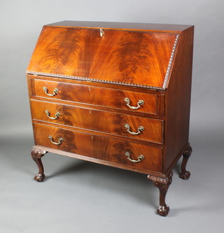 A 1930's carved mahogany Chippendale style bureau, the fall front revealing a well fitted interior above 3 long graduated drawers with brass drop handles, raised on cabriole supports 40"h x 36"w x 18"d 