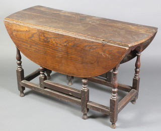 An 18th Century oak oval drop flap gateleg dining table, raised on turned supports 27 1/2" x 46 1/2"w x 17" when closed x 41" when extended 