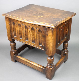 An oak joined box with hinged lid and linen fold decoration, raised on turned and block supports 16"h x 17"w x 12 1/2"d 