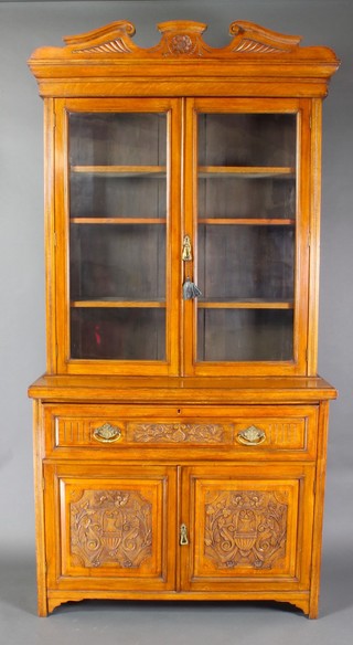 A late Victorian oak secretaire bookcase the upper section with moulded cornice, fitted shelves enclosed by glazed panelled doors, the base fitted a secretaire drawer and drawers above a cupboard enclosed by panelled doors 95"h x 49"w x 18"d 