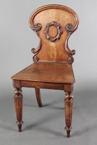 A 19th Century mahogany shield shaped hall chair with solid seat raised on turned and chamfered supports 