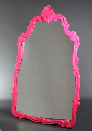 A shaped plate mirror contained in a carved pink painted wooden frame 67"h x 38"w 
