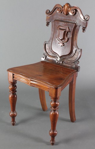 A Victorian mahogany hall chair with shaped back, the seat of serpentine outline, raised on turned supports 