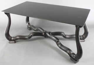 A "Designer" X framed ebonised dining table, raised on shaped supports with black plate glass top 26"h  x 54"l x 30"w