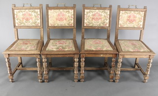 A set of 4 Art Nouveau French oak dining chairs with upholstered seats and backs, raised on turned supports with H framed stretchers