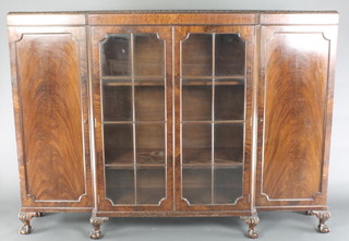 A Chippendale style mahogany triple breakfront bookcase, the centre section fitted adjustable shelves enclosed by panelled doors flanked by a pair of cupboards enclosed by panelled doors and raised on cabriole ball and claw supports 52"h x 72"w x 15"d 