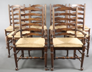 A set of 8 (2 and 6) elm ladder back dining chairs with woven rush seats, raised on turned supports with box framed stretcher 