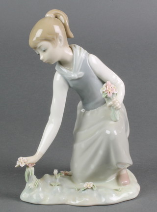A Lladro figure of a kneeling girl picking flowers 8"