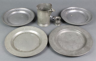 An 18th Century pewter plate with London touch mark 10", 1 other, 2 circular pewter plates the reverse marked X 9", a Victorian pewter spouted measure and a baluster spirit measure 
