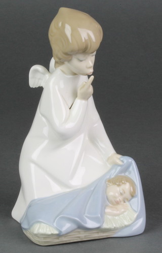 A Lladro figure of an angel kneeling before a sleeping child 4635 7", boxed