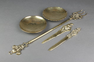 A brass paper knife, the handle in the form of a seated Pan 8" and 1 other paper knife 8", a brass toasting fork decorated St George and 2 Chinese polished brass dishes 5 1/2" 