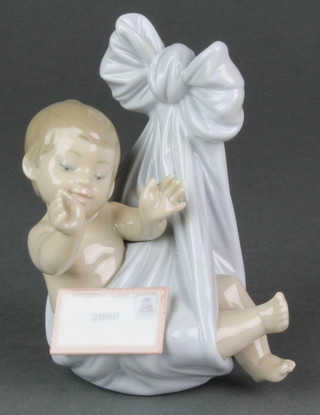 A Lladro figure of a baby in a tied  blanket holding a letter A28JU 5 1/2" 