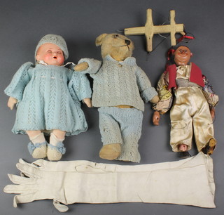A porcelain headed doll with sleep eyes, open mouth and 2 teeth, having a fabric body and a naive wooden puppet of a minstrel, a yellow teddy bear 13"   