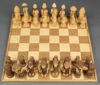 A Nigerian carved wooden figural chess set complete with board