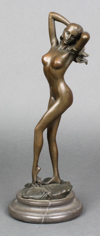 A bronze figure of a standing naked girl, raised on a circular marble base 11" 