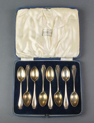 A cased set of 8 silver coffee spoons with fancy handles, London 1938, 74 grams