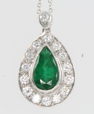 A pear shaped emerald and diamond pendant, the emerald approx 1.5ct surrounded by 14 brilliant cut diamonds and 1 diamond support, on an 18ct white gold chain 