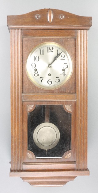 A 1930's chiming wall clock with 7" dial and Arabic numerals contained in an oak case 
