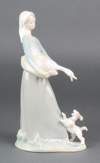 A Lladro figure of a young lady holding a goose with a puppy at her feet 10 1/2" 