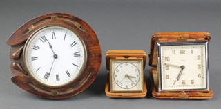 A 19th Century timepiece with enamelled dial and Roman numerals contained in a carved oak case in the form of a horseshoe 5", a Smiths travel alarm clock contained in a leather case decorated a coat of arms, 1 other and a travel alarm clock contained in a leather case 