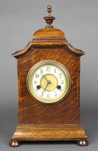 A Hamburg American Clock Co. striking mantel clock with enamelled dial and Arabic numerals contained in an ok case, raised on bun feet 