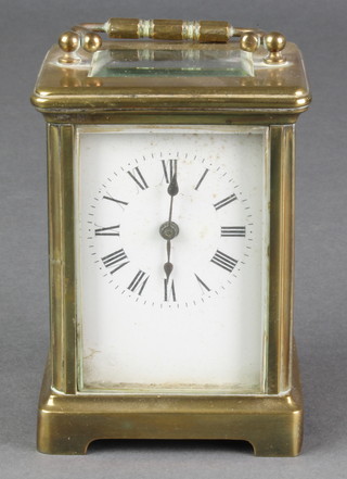 A French 8 day carriage clock with enamelled dial and Roman numerals, contained in a gilt metal case 