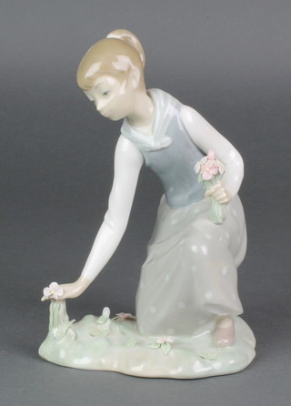 A Lladro figure of a young lady picking flowers 8" 