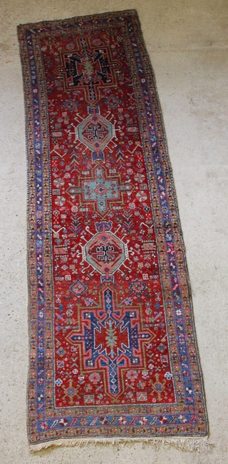 A Heriz Persian runner 121" x 37",  in wear and missing fringing to 1 edge 