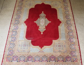 A red and gold ground Persian Kirman carpet with central medallion 161" x 124", some wear
