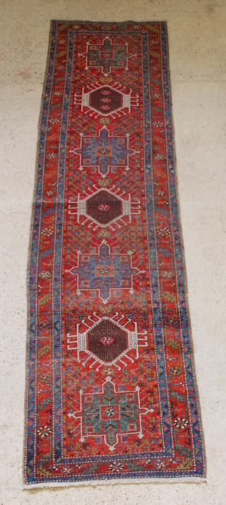 A tan and blue ground Heriz runner with 7 stylised medallions to the centre 127" x 35", in wear